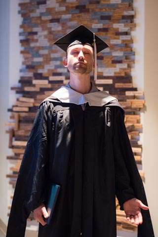 graduate posing in regalia.