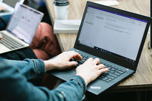 student typing at computer