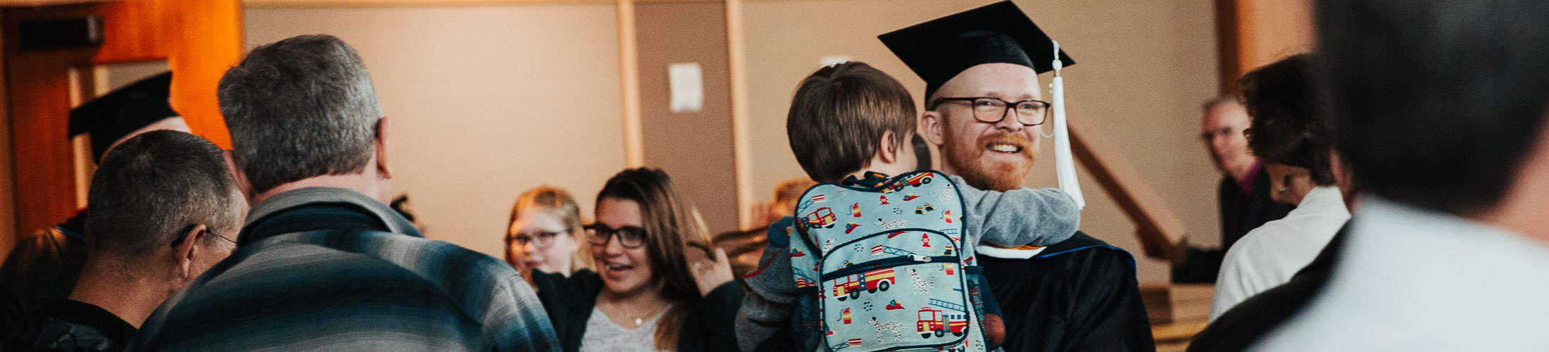 student at graduation with child
